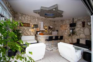 a restaurant with white chairs and a stone wall at Mejić Apartments in Kotor