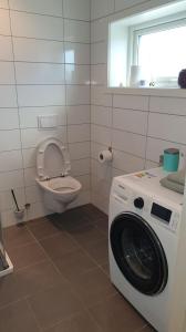 a washing machine in a bathroom with a toilet at Modern basement apartments Stavanger, Sola airport, Kjerag, Preikestolen in Stavanger