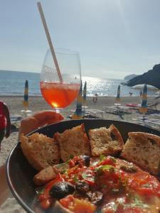una persona che tiene in mano un piatto di cibo e una bevanda di B&B La Menaica a Marina di Camerota
