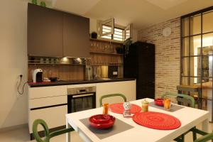 a kitchen with a white table and green chairs at BALATA home in Marina di Ragusa