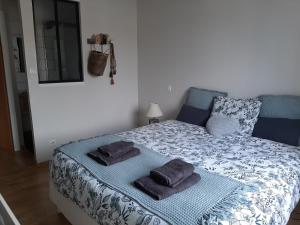 a bedroom with a bed with towels on it at Maison chaleureuse et familiale in Carcassonne