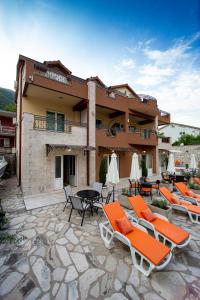 a patio with chairs and tables and a building at Mejić Apartments in Kotor