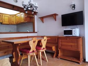 jadalnia ze stołem i telewizorem w obiekcie Stella alpina w mieście Sappada