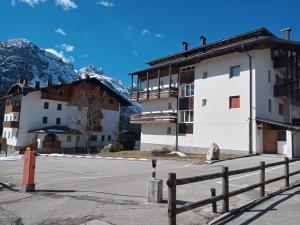 a building on the side of a street with mountains at Stella alpina in Sappada