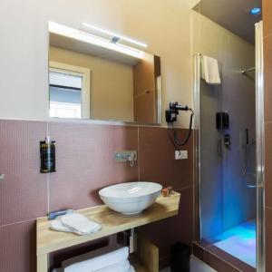 een badkamer met een wastafel, een spiegel en een douche bij Euphoria al Duomo in Napels