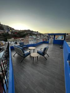 einen Balkon mit Stühlen und Tischen sowie Stadtblick in der Unterkunft Casa Dos Fridas - Centro Guanajuato in Guanajuato