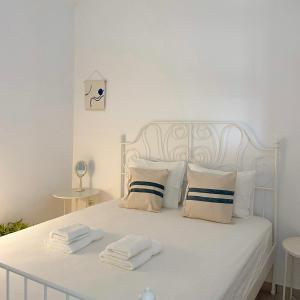 a white bed with two folded towels on it at Vanis House Sunset View Kythira in Kythira