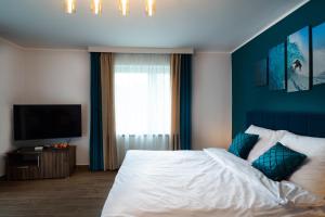 1 dormitorio con 1 cama con pared azul en Apartament Zielony Przylądek, en Brwinów