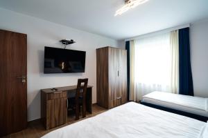 Habitación de hotel con cama y escritorio con TV. en Apartament Zielony Przylądek, en Brwinów