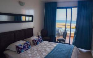 a bedroom with a bed and a view of the ocean at Auberge Oualidia Dream in Oualidia