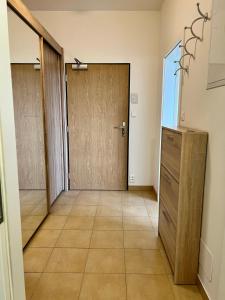 a hallway with a wooden door and a tiled floor at Apartment Prague-2 rooms free parking in Prague