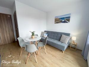 a living room with a couch and a table and chairs at Stacja Bałtyk in Karwia