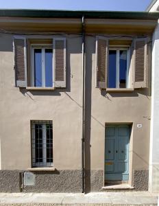 un edificio con dos ventanas y una puerta azul en Maison B en Mantova