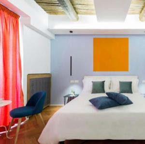 een slaapkamer met een groot bed en een blauwe stoel bij Euphoria al Duomo in Napels