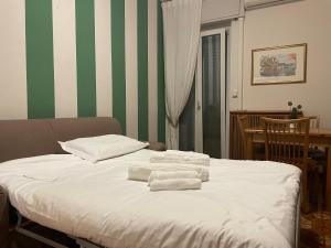 ein Schlafzimmer mit einem Bett mit Handtüchern darauf in der Unterkunft Apartment Station Sesto - Affitti Brevi Italia in Sesto San Giovanni