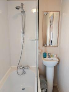 a bathroom with a shower and a sink at Vista Al Mar, Seaview Caravan Park, Whitstable in Kent