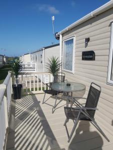 a patio with a table and chairs on a balcony at Vista Al Mar, Seaview Caravan Park, Whitstable in Kent