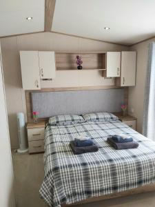Kent的住宿－Vista Al Mar, Seaview Caravan Park, Whitstable，一间卧室配有一张带两个枕头的床
