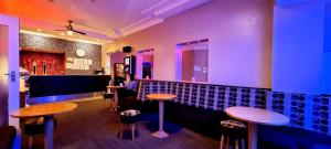 a bar with two tables and stools in a room at The Avari Beach Hotel in Blackpool