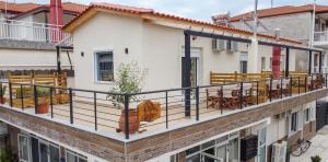 a balcony with tables and benches on a building at Lila's Studios in Asprovalta