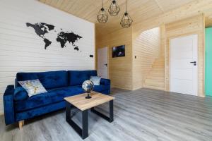 una sala de estar con un sofá azul y un mapa mundial en la pared en Planeta 66, en Olsztynek