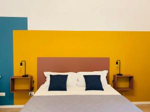 una camera da letto con un grande letto con una parete gialla di Dimora Lupo_LifeStyle B&B a Catania