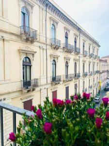 a building with pink flowers in front of it at Dimora Lupo_LifeStyle B&B in Catania
