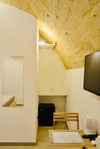 a room with a table and a tv on a ceiling at Arvian B&B in Bari