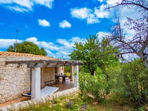 an external view of a stone house with a table in the yard at Casa Bedda in Noto Marina