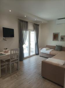 Villa Christos Family Bungalow Pachis Beach في باتشيس: غرفة معيشة مع سرير ومكتب وأريكة