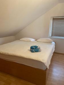 a bed with two pillows and a bag on it at Villa Enio in Bihać +26 photos