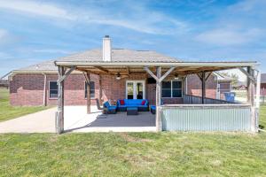 a patio with blue furniture on a brick house at Perfect Stay in Ranch-like House w Huge Backyard! in Forney