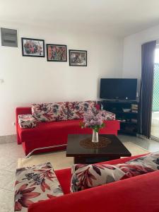 Una sala de estar con un sofá rojo y un televisor. en Villa Enio, en Bihać