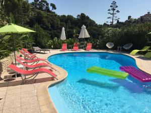 a swimming pool with chairs and umbrellas at VILLA LES YUCCAS - Pool - Sea view in Cagnes-sur-Mer