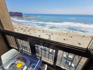 a view of a beach and the ocean from a balcony at Playa apartamento in Torrevieja
