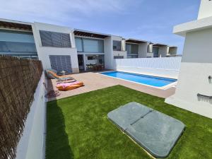 a house with a swimming pool and a yard at Meco Beach Villa in Sesimbra