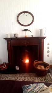 a fire in a fireplace with a mirror above it at Paula's Cottage in New Pitsligo