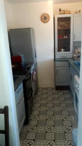 uma cozinha com um frigorífico e piso em azulejo em Paula's Cottage em New Pitsligo