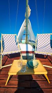 stół i dwa krzesła na łodzi w obiekcie Sirius - Boat House w mieście Olhão