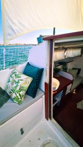 un asiento en la parte trasera de un barco con una mesa en Sirius - Boat House, en Olhão