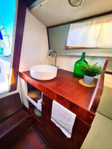 a bathroom with a sink on a wooden counter at Sirius - Boat House in Olhão