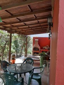 eine Terrasse mit einem Tisch, Stühlen und einem Grill in der Unterkunft FINCA EL PEDREGAL in Valsequillo de Gran Canaria