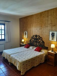 ein Schlafzimmer mit einem großen Bett mit roten Kissen in der Unterkunft FINCA EL PEDREGAL in Valsequillo de Gran Canaria