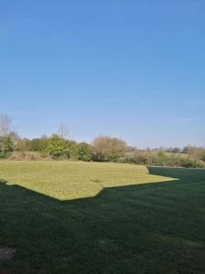 un grand champ d'herbe avec une grande ombre sur celui-ci dans l'établissement appartement meublés, à Coutances