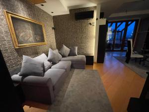 a living room with couches and a brick wall at Attico con vista spettacolare e Jacuzzi in Bologna