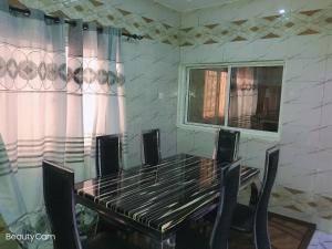 AbukoAwaMuuLamin MANNEH GUEST HOUSE的餐桌、椅子和窗户