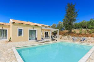 a swimming pool in front of a house at Villa Christina in Pouládes