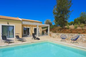 a swimming pool with chairs and a house at Villa Christina in Pouládes