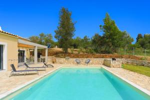 a swimming pool in a yard with two chairs at Villa Christina in Pouládes