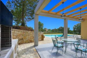 a patio with a table and chairs and a pool at Villa Christina in Pouládes